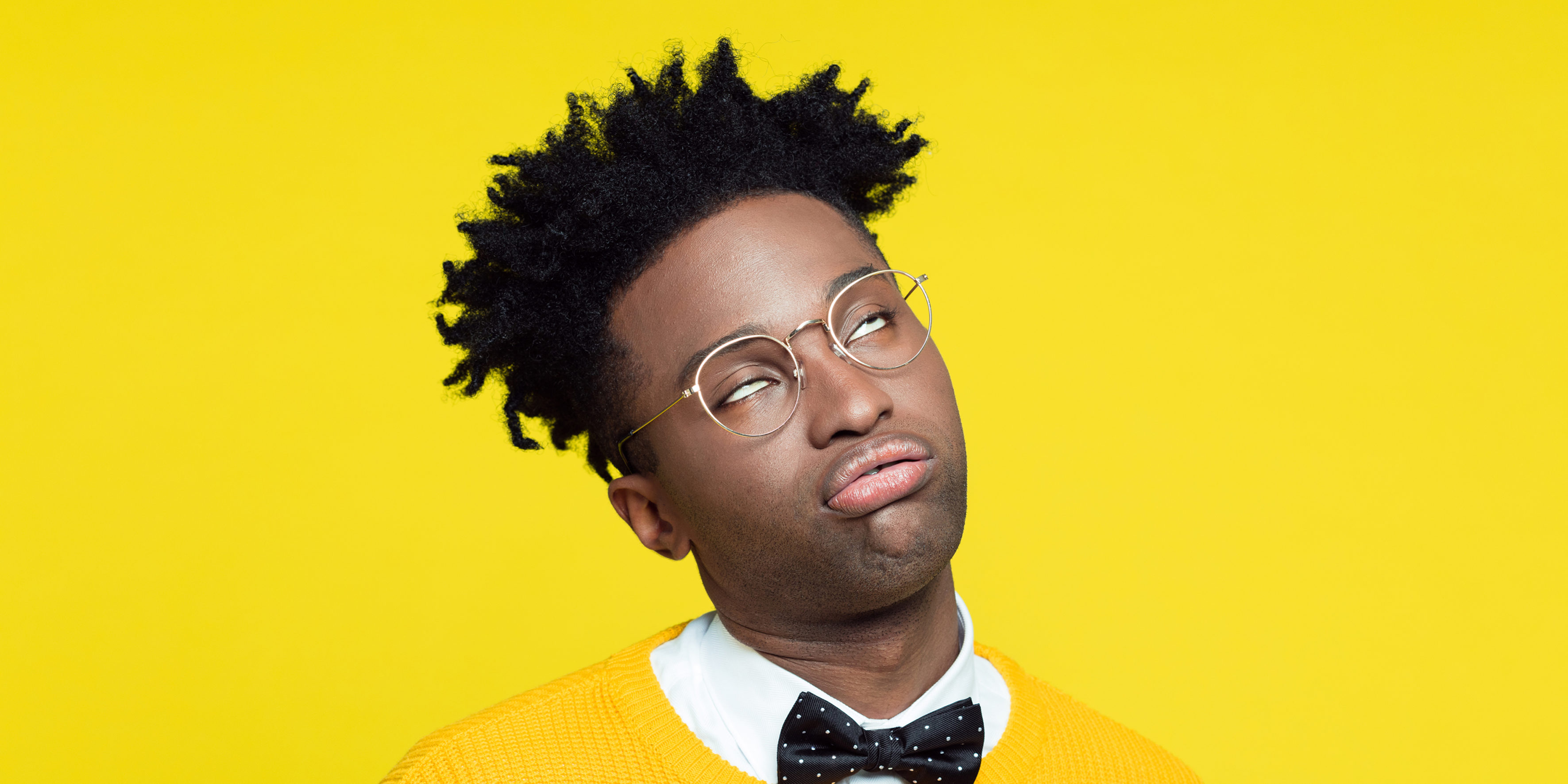 Portrait of bored geeky young man in retro style against yellow background